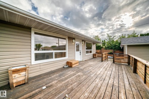 Expansive wood deck with a privacy fence and a dedicated entry door, featuring vinyl siding - 7603 130 Avenue Nw, Edmonton, AB - Outdoor With Deck Patio Veranda With Exterior