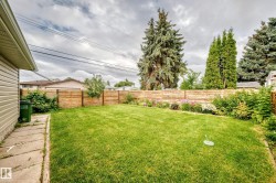 Expansive lawn area with a wood fence perimeter - 