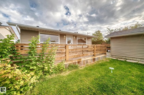 Rear exterior with wood decking, horizontal wood fencing, and a detached structure with siding - 7603 130 Avenue Nw, Edmonton, AB - Outdoor