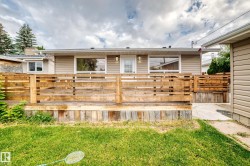 Wood deck with horizontal railing, siding exterior, and multiple windows - 