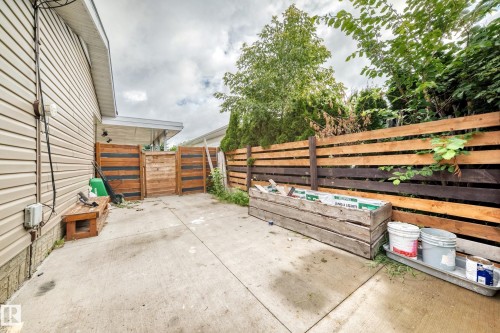 Poured concrete patio with a two-tone horizontal wood fence and natural wood privacy screens - 7603 130 Avenue Nw, Edmonton, AB - Outdoor