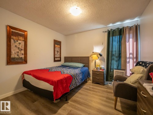 Wood-finish flooring with a neutral wall color and ceiling-mounted light fixture - #No 510 Abbottsfield Rd Nw Nw, Edmonton, AB - Indoor Photo Showing Bedroom