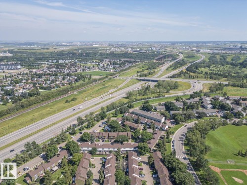 Aerial perspective showcasing a residential community with mature landscaping, adjacent to an expansive highway system - #No 510 Abbottsfield Rd Nw Nw, Edmonton, AB - Outdoor With View