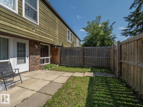 Private outdoor space with a concrete paver patio, partial grass area, and wood privacy fencing - #No 510 Abbottsfield Rd Nw Nw, Edmonton, AB - Outdoor