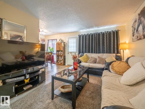 Wood-finish flooring, textured ceiling, built-in shelving, and recessed lighting - #No 510 Abbottsfield Rd Nw Nw, Edmonton, AB - Indoor Photo Showing Living Room