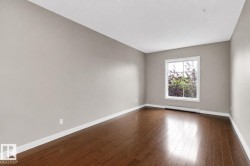 Rich wood-finish flooring, neutral wall tones, and a white-framed window - 