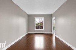 Hardwood-finish flooring, neutral wall tones, white window trim, and white baseboards - 
