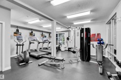 Fitness area featuring cardio equipment, strength training machines, and a durable rubberized floor - 