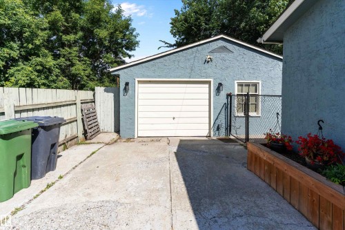 Detached garage with a paneled door, exterior wall sconces, and a side window - 5404 45 Avenue, Wetaskiwin, AB - Outdoor With Exterior