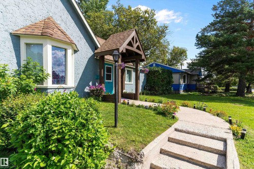 Stucco exterior with a bay window, covered entry, and a concrete pathway - 5404 45 Avenue, Wetaskiwin, AB - Outdoor