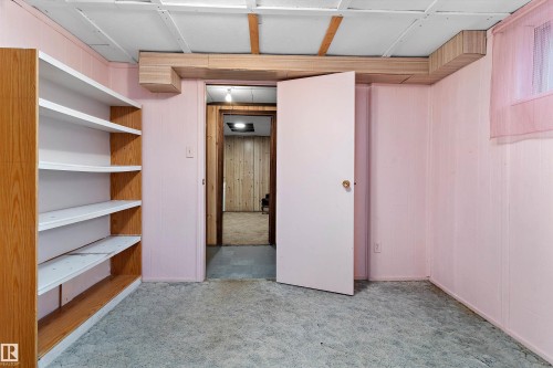 Built-in shelving unit with multiple tiers, textured carpeting, and a drop ceiling - 5404 45 Avenue, Wetaskiwin, AB - Indoor