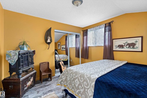 Wood-finish flooring, mirrored sliding closet doors, and recessed window - 5404 45 Avenue, Wetaskiwin, AB - Indoor Photo Showing Bedroom