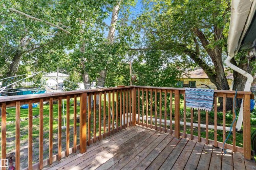 Outdoor wood deck with wood railings overlooking a green lawn - 5404 45 Avenue, Wetaskiwin, AB - Outdoor With Deck Patio Veranda