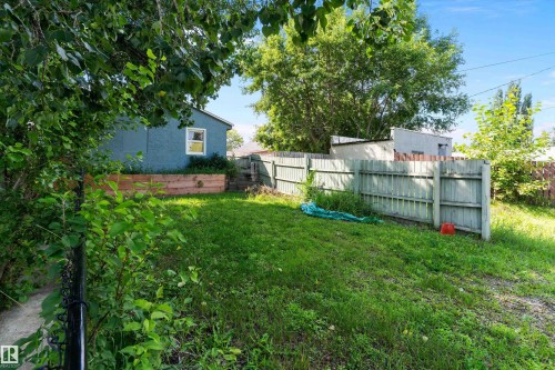 Expansive grassy yard with a privacy fence and mature trees - 5404 45 Avenue, Wetaskiwin, AB - Outdoor