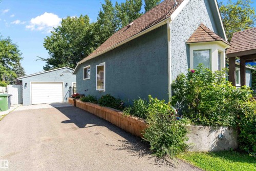 Stucco exterior with a bay window, asphalt shingle roof, and established landscaping - 5404 45 Avenue, Wetaskiwin, AB - Outdoor