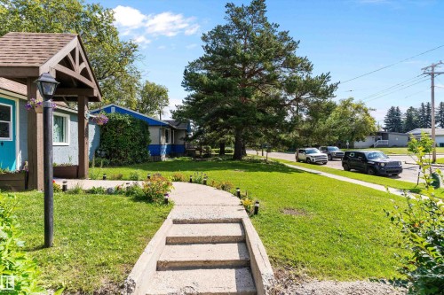 Concrete walkway with steps, leading to a covered entry with a wooden archway - 5404 45 Avenue, Wetaskiwin, AB - Outdoor