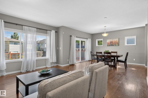 Open-concept living space featuring wood-finish flooring, abundant natural light, and a sliding glass door - 9515 221 Street Nw, Edmonton, AB - Indoor Photo Showing Living Room