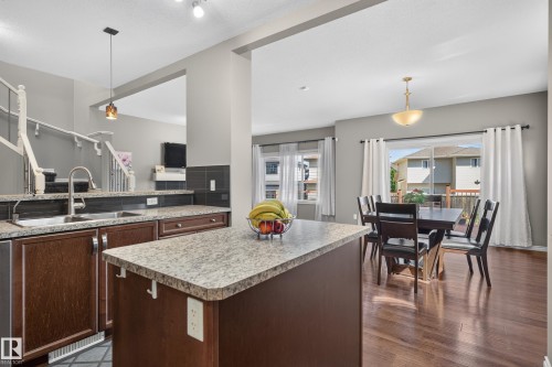 Kitchen featuring a double basin sink, dark wood-finish cabinetry, and light-toned countertops - 9515 221 Street Nw, Edmonton, AB - Indoor