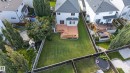 Expansive backyard featuring a manicured lawn, multi-level wood deck, and perimeter fencing - 9515 221 Street Nw, Edmonton, AB  - Outdoor 