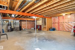 Spacious unfinished basement with exposed wood joists and concrete flooring - 