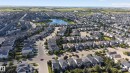 Aerial perspective showcasing a residential community with a central body of water, multiple homes with grey shingled roofs, and established streets - 9515 221 Street Nw, Edmonton, AB  - Outdoor With View 