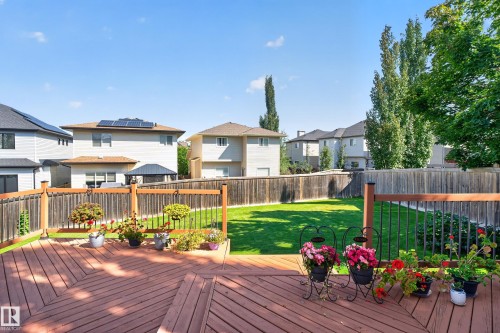 Expansive wooden deck with railing, featuring a manicured lawn and privacy fencing - 9515 221 Street Nw, Edmonton, AB - Outdoor With Deck Patio Veranda