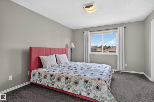 Neutral-toned walls complement the dark grey carpeting - 9515 221 Street Nw, Edmonton, AB - Indoor Photo Showing Bedroom