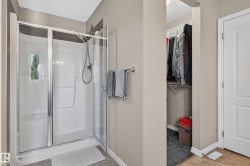 Enclosed shower with a glass door, brushed nickel hardware, and built-in shelving - 