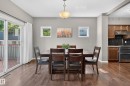 Dining area featuring wood-finish flooring, two large windows, and a sliding glass door providing exterior access - 9515 221 Street Nw, Edmonton, AB  - Indoor Photo Showing Dining Room 
