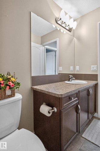 Vanity with a laminate countertop, integrated sink, and dark wood-finish cabinetry - 9515 221 Street Nw, Edmonton, AB - Indoor Photo Showing Bathroom