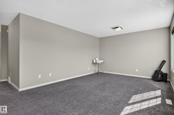 Spacious room featuring neutral wall paint, gray carpeting, and a flush-mount ceiling light - 