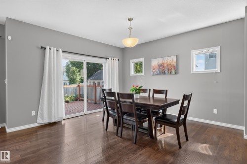 Hardwood-finish flooring, light gray wall color, pendant light fixture, sliding glass door, and a wooden deck - 9515 221 Street Nw, Edmonton, AB - Indoor Photo Showing Dining Room