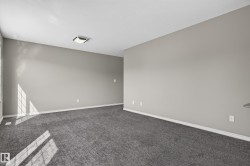 Neutral wall color with white trim, gray carpeting, and a flush-mount ceiling light - 