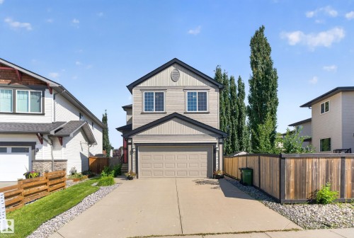 Two-story home with a two-car garage, concrete driveway, and wood privacy fencing - 9515 221 Street Nw, Edmonton, AB - Outdoor
