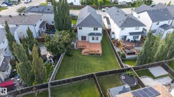 Spacious backyard featuring a multi-level wood deck, expansive lawn, and mature trees - 