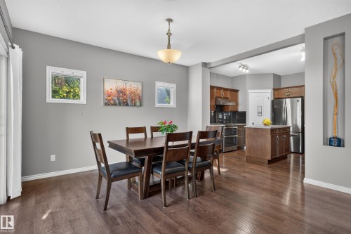 Open-concept dining area with wood-finish flooring, a contemporary chandelier, and recessed wall niche - 9515 221 Street Nw, Edmonton, AB - Indoor Photo Showing Dining Room