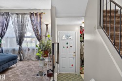 Entryway with a paneled door, arched glass insert, and adjacent open shelving - 