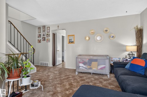 Wall-to-wall carpeting, staircase with metal railing, and light gray wall paint - 18247 93 Avenue Nw, Edmonton, AB - Indoor