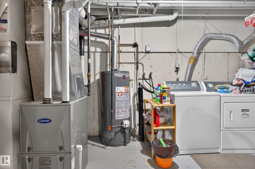 Carrier brand furnace, water heater, and a washer and dryer set - 18247 93 Avenue Nw, Edmonton, AB - Indoor Photo Showing Basement