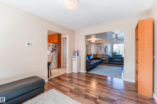 Wood-finish flooring throughout, light neutral wall paint, and a built-in shelving unit - 4609 38A Avenue Nw, Edmonton, AB - Indoor