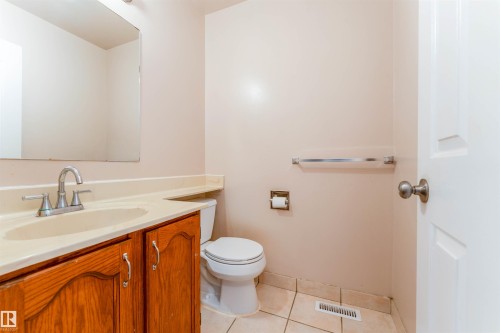 Vanity with wood-finish cabinetry, integrated sink, and chrome faucet - 4609 38A Avenue Nw, Edmonton, AB - Indoor Photo Showing Bathroom