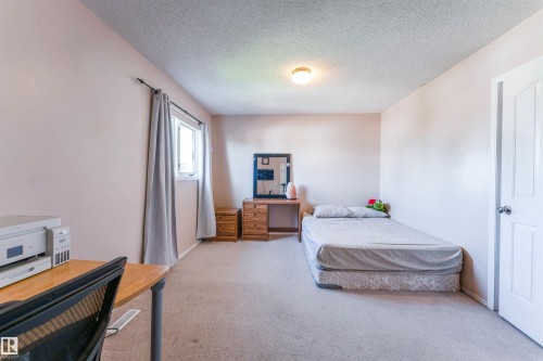 Neutral wall color, carpeted flooring, and a single window with curtain rods - 4609 38A Avenue Nw, Edmonton, AB - Indoor Photo Showing Bedroom