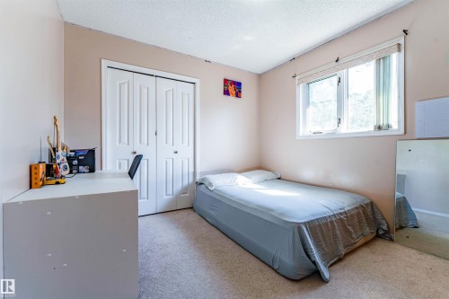 Wall-to-wall carpeting with bi-fold closet doors and a single window - 4609 38A Avenue Nw, Edmonton, AB - Indoor Photo Showing Bedroom