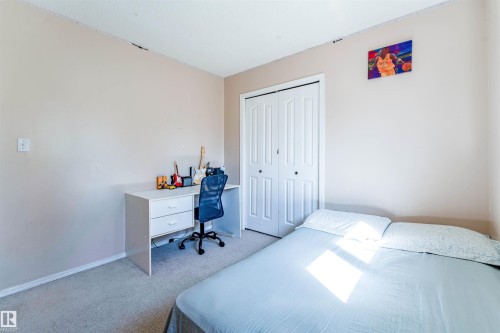 Neutral tone wall paint, carpet flooring, and bi-fold closet doors - 4609 38A Avenue Nw, Edmonton, AB - Indoor Photo Showing Bedroom