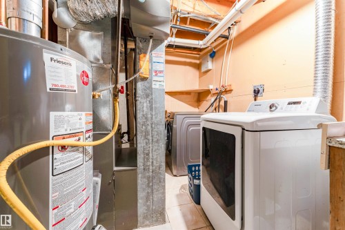 Utility area featuring a water heater, furnace, and laundry appliances - 4609 38A Avenue Nw, Edmonton, AB - Indoor Photo Showing Laundry Room