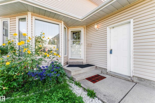 Light-toned horizontal siding exterior featuring a bay window, concrete steps, and a panel door - 4609 38A Avenue Nw, Edmonton, AB - Outdoor