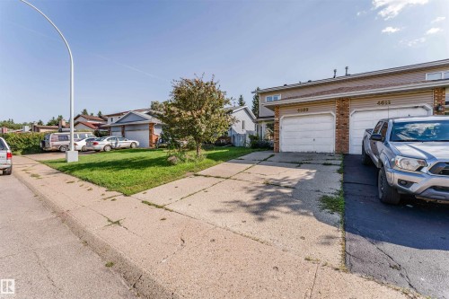 Attached garage with panel doors, brick facade, and asphalt shingle roof - 4609 38A Avenue Nw, Edmonton, AB - Outdoor