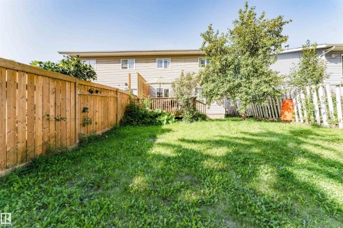 Expansive fenced backyard featuring a wooden privacy fence, mature trees, and a wooden deck with railing - 4609 38A Avenue Nw, Edmonton, AB - Outdoor