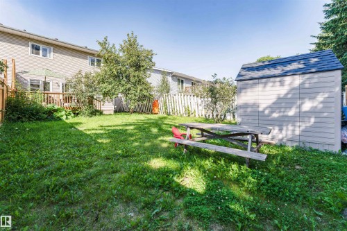 Expansive backyard with a wooden deck, mature trees, and a storage shed featuring a shingled roof - 4609 38A Avenue Nw, Edmonton, AB - Outdoor