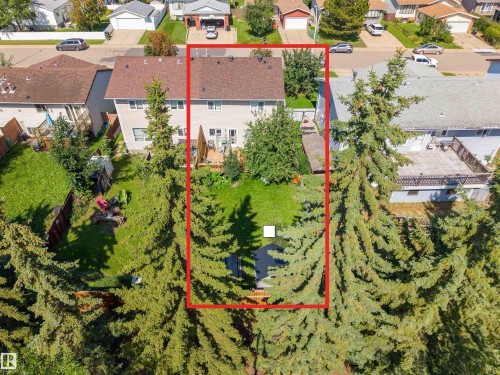 Expansive backyard with a manicured lawn, mature evergreen trees, and a wooden deck - 4609 38A Avenue Nw, Edmonton, AB - Outdoor With View